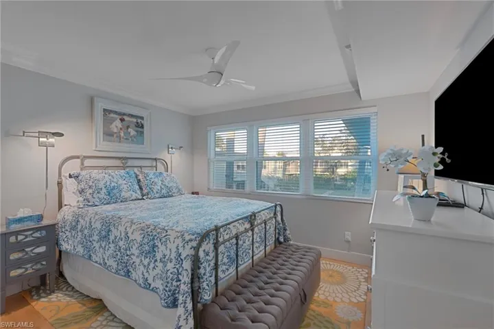 Bedroom with crown molding, a ceiling fan, and light wood finished floors