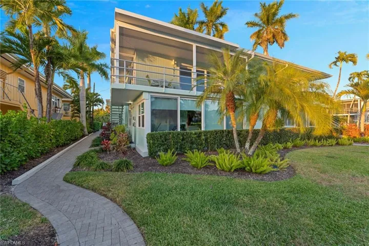 Rear view of house with a balcony and a lawn