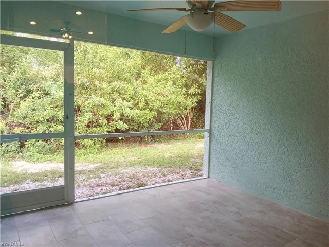 Unfurnished sunroom featuring plenty of natural light and ceiling fan