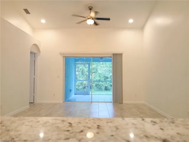 Tiled spare room featuring ceiling fan