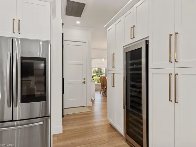 Kitchen with a sink, ornamental molding, a peninsula, stainless steel appliances, and light wood-style flooring