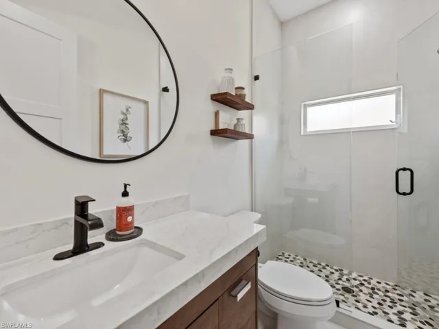 Bathroom with a shower stall, a sink, and a wealth of natural light