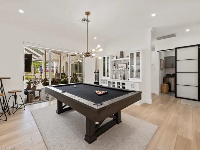 Dining area with light wood-style flooring, ornamental molding, baseboards, and a sunroom