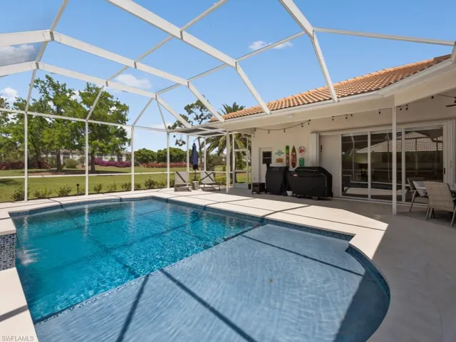 Outdoor pool with a patio area and glass enclosure