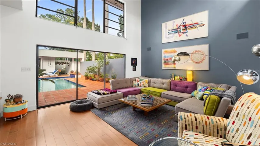 Living room with hardwood / wood-style floors and a towering ceiling