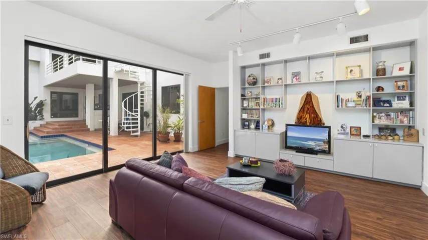 Living room with rail lighting, wood finished floors, and a ceiling fan