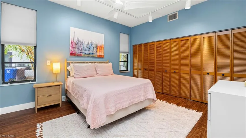 Bedroom featuring track lighting, a closet, and dark wood-style flooring