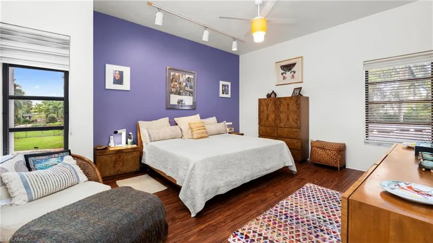 Bedroom with rail lighting and dark wood-style floors