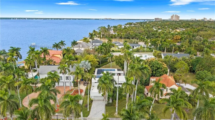 Aerial view of property's location with a nearby body of water and nearby suburban area