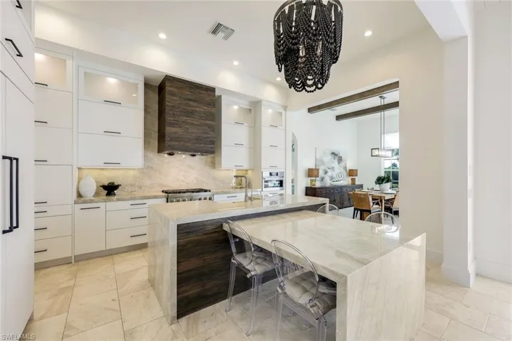 Kitchen featuring modern cabinets, tasteful backsplash, a chandelier, stainless steel oven, and recessed lighting