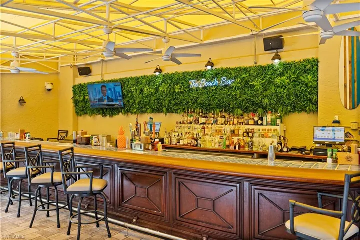 Beach Club Community bar area featuring a textured wall and ceiling fan