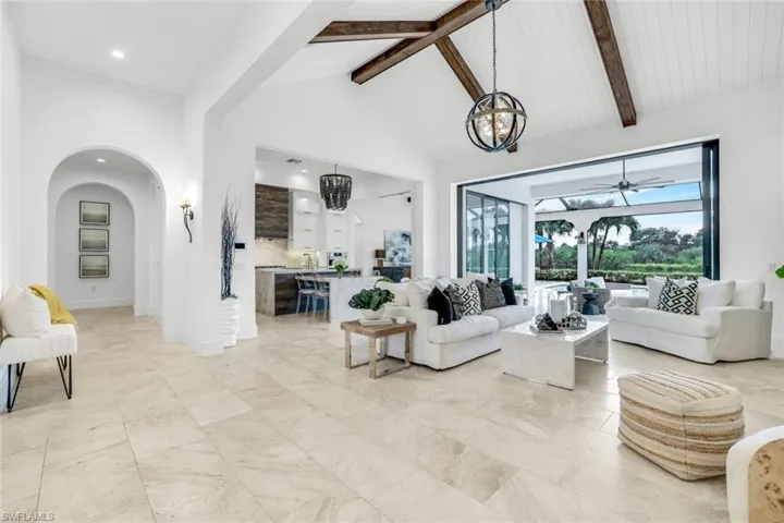Living area with beamed ceiling, high vaulted ceiling, and arched walkways