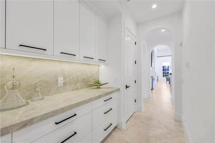 Hallway with arched walkways and recessed lighting