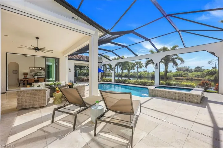 View of swimming pool with a patio area, ceiling fan, glass enclosure, and a pool with connected hot tub