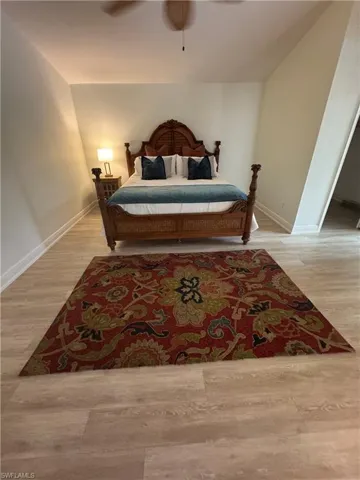 Bedroom featuring light wood finished floors, a ceiling fan, and lofted ceiling