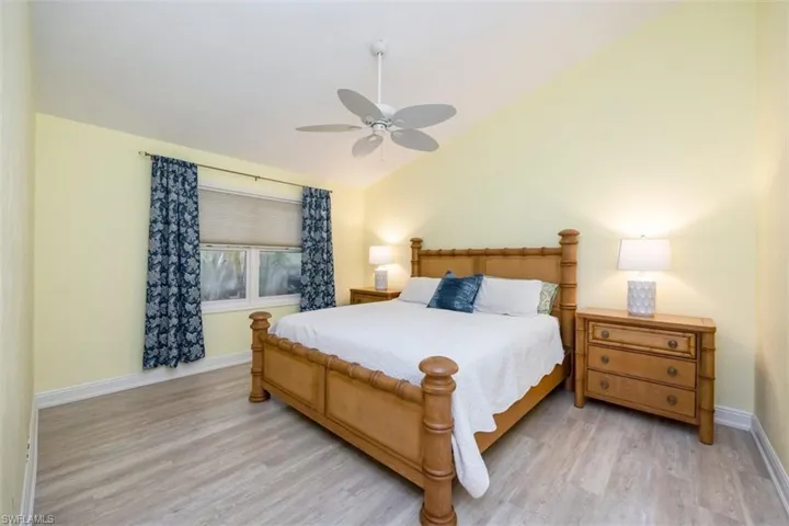 Guest Bedroom 2 featuring ceiling fan, light wood-style floors, and high vaulted ceiling