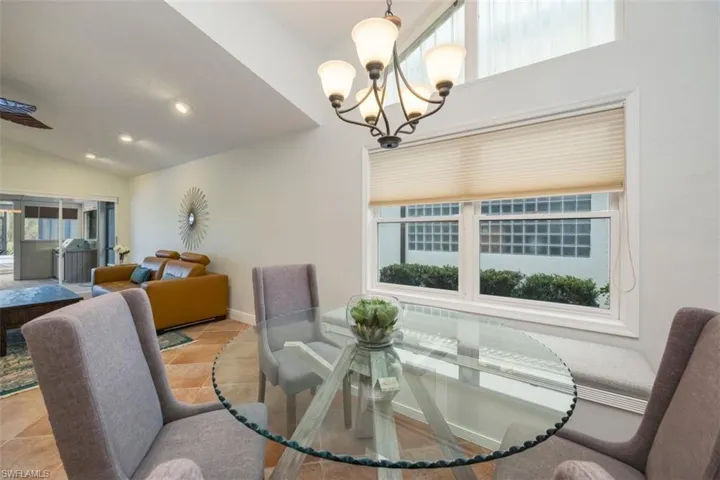 Dining space with vaulted ceiling, recessed lighting, a ceiling fan, and a chandelier