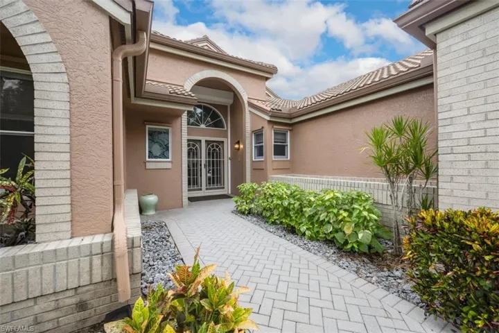 View of exterior entry featuring stucco siding and french doors