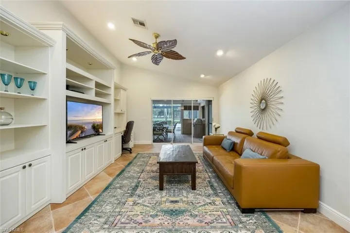 Living room featuring a desk, lofted ceiling, a ceiling fan, light tile patterned flooring, and recessed lighting