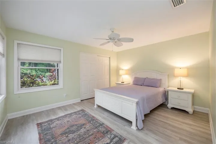 Guest Bedroom 1 featuring light wood finished floors, a ceiling fan, and a closet