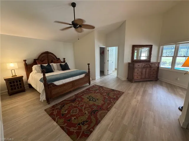 Bedroom featuring light wood-style floors, high vaulted ceiling, and ceiling fan