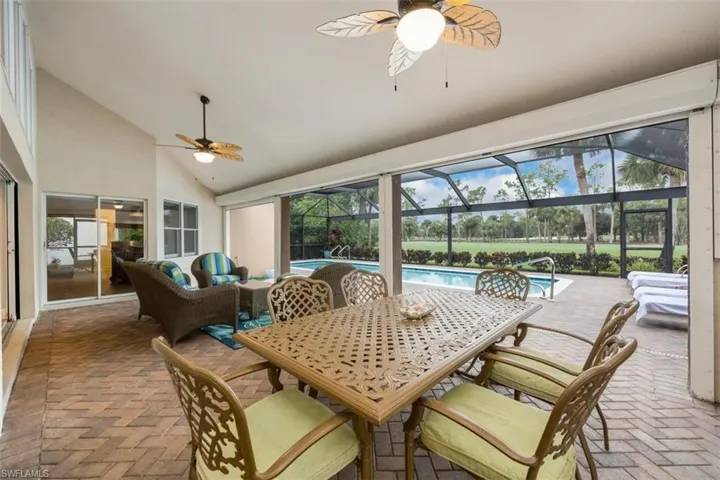 Sunroom / solarium with lofted ceiling, a ceiling fan, a patio, and an outdoor living space