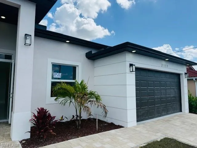 View of home's exterior with a garage, stucco siding, and driveway