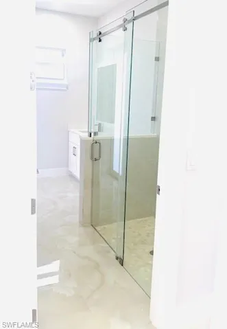 Bathroom with a stall shower, vanity, and light marble finish flooring