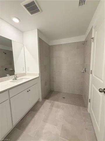 Bathroom featuring a stall shower, vanity, and recessed lighting