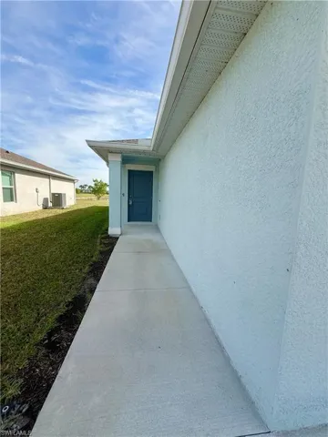 Entrance to property featuring a lawn and stucco siding