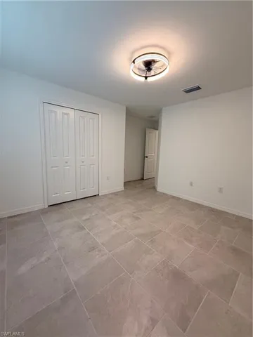 Unfurnished bedroom with baseboards and a closet