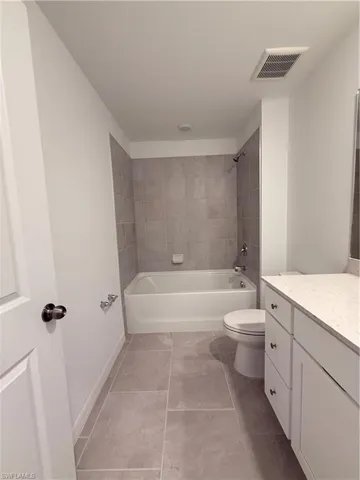 Full bath featuring vanity, shower / washtub combination, and light tile patterned floors