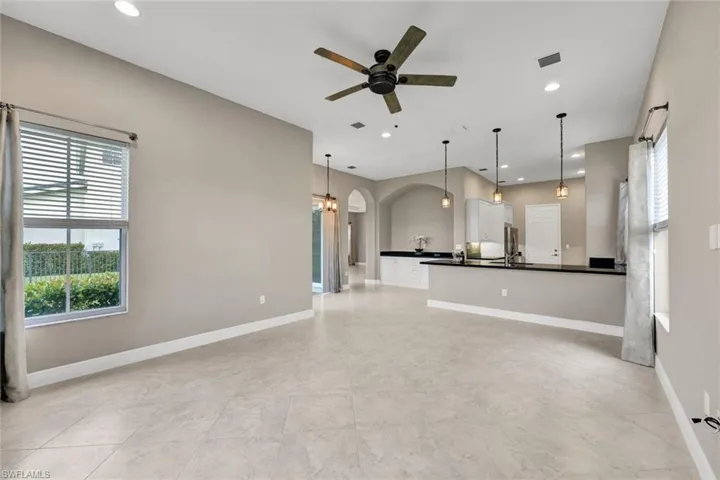 Kitchen with kitchen peninsula, white cabinetry, and decorative light fixtures