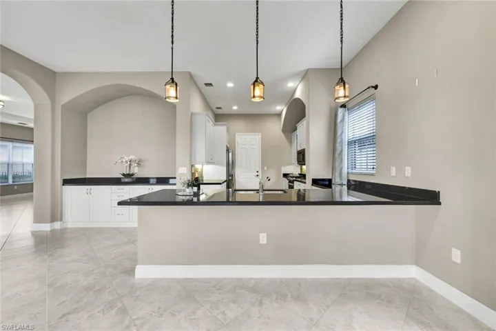 Kitchen featuring tasteful backsplash, ceiling fan, hanging light fixtures, and stainless steel appliances