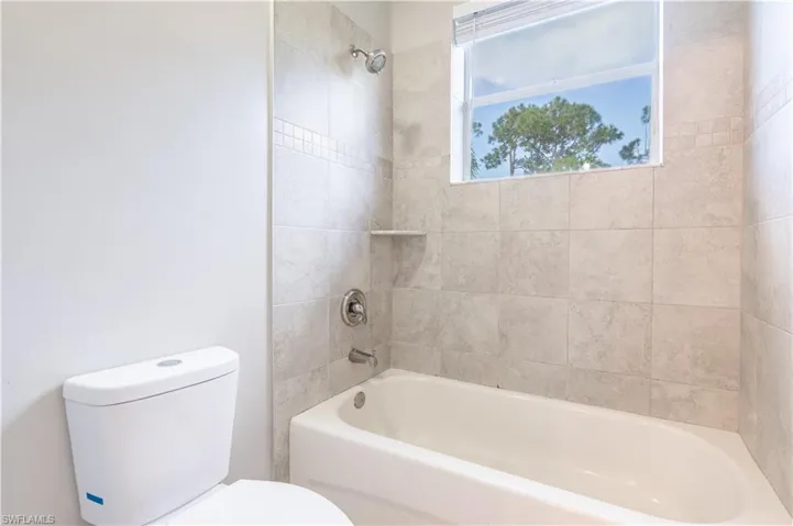 Full bathroom featuring washtub / shower combination and toilet