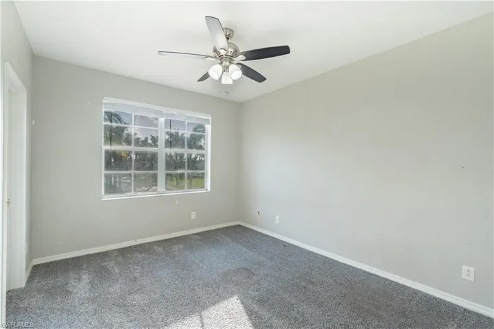 Carpeted bedroom 3 featuring baseboards and a ceiling fan