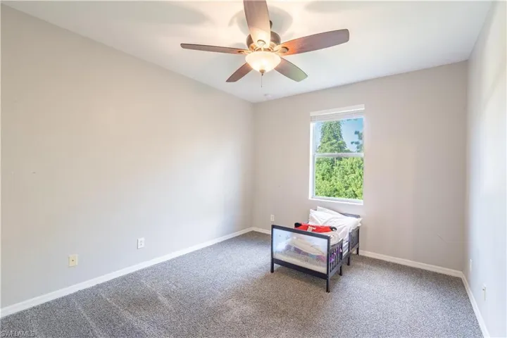 Carpeted bedroom 4 featuring ceiling fan and baseboards