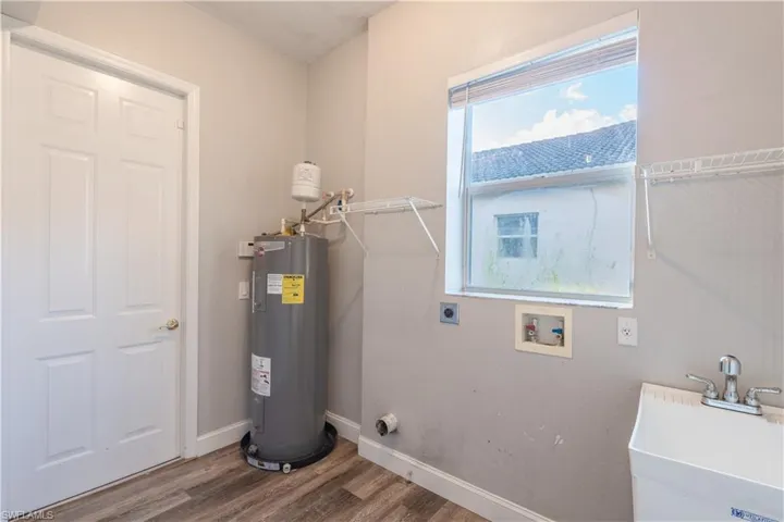 Laundry room with a sink and water heater