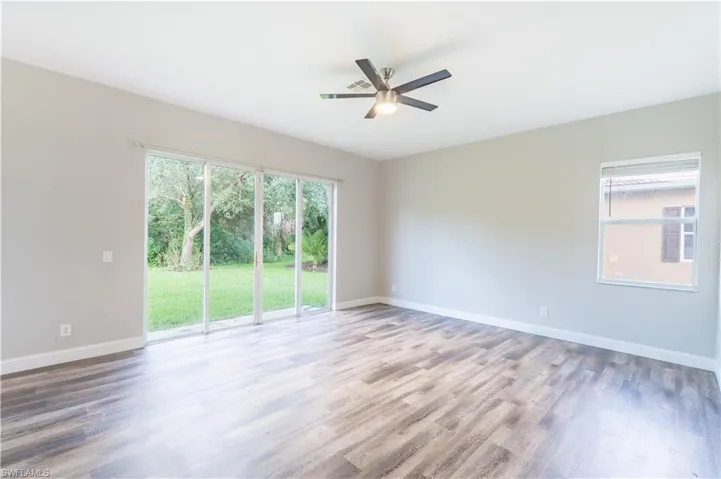 Unfurnished formal living room featuring wood finished floors and ceiling fan