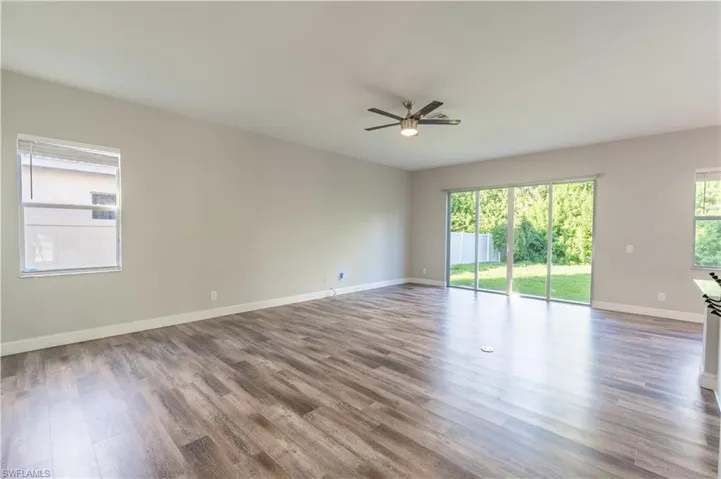 Unfurnished room featuring plenty of natural light, wood finished floors, and a ceiling fan