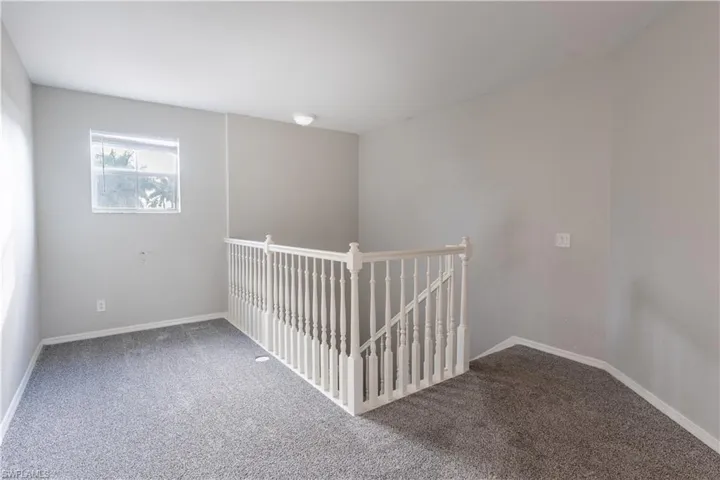 Carpeted small loft area featuring baseboards