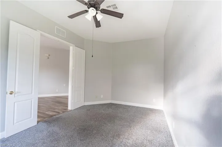 Carpeted office/den room featuring baseboards and ceiling fan
