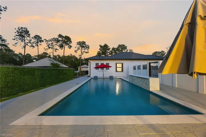 Rectangular swimming pool featuring a light-toned coping and surrounding patio