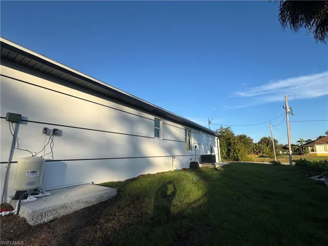 View of side of property with a lawn