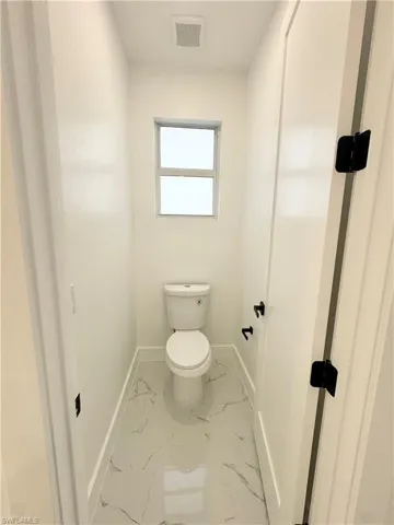 Bathroom with baseboards and light marble finish floors