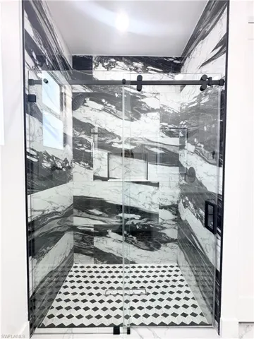 Full bathroom with a marble finish shower