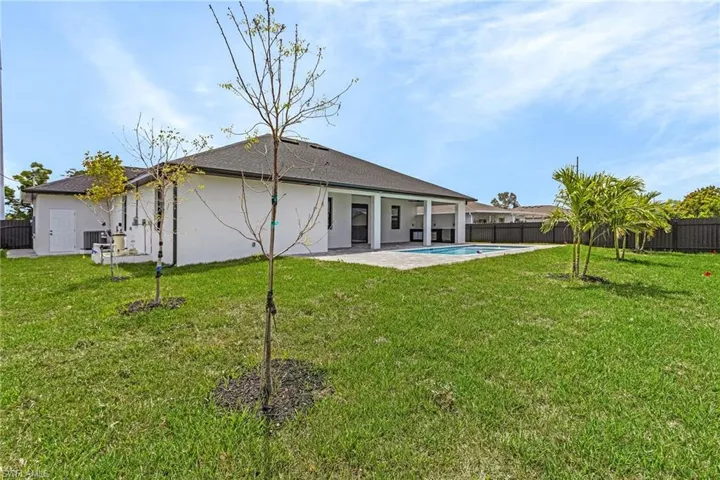 Back of house with a lawn, stucco siding, and a fenced backyard