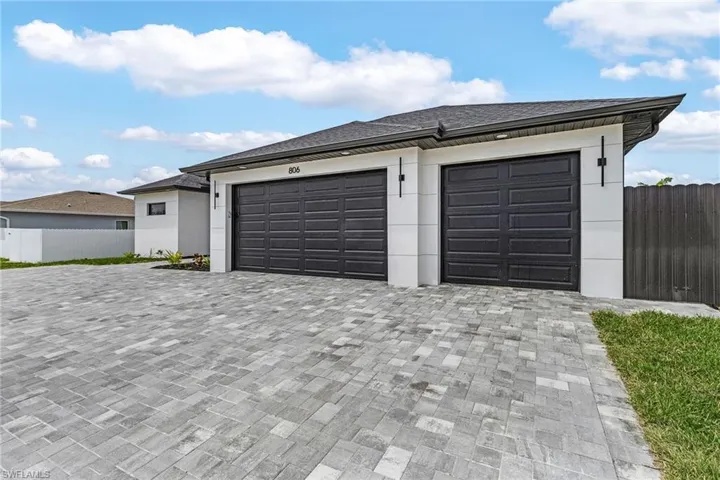 Garage featuring fence and paved driveway