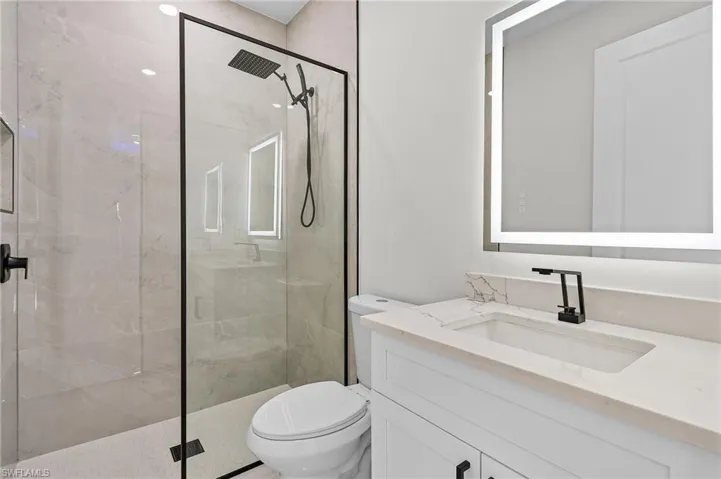 Full bathroom with vanity, toilet, and a stall shower