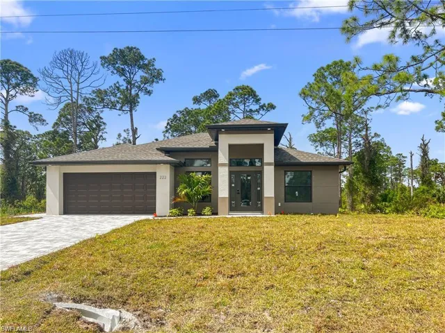 View of front facade with a front lawn and a garage
